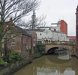 Riverside buildings with a stone arch bridge spanning a river