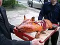 Roast suckling pig bearing 囍 (Double Happiness) placard at a Cantonese wedding