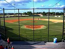 A view of a baseball diamond from the seats behind home plate.