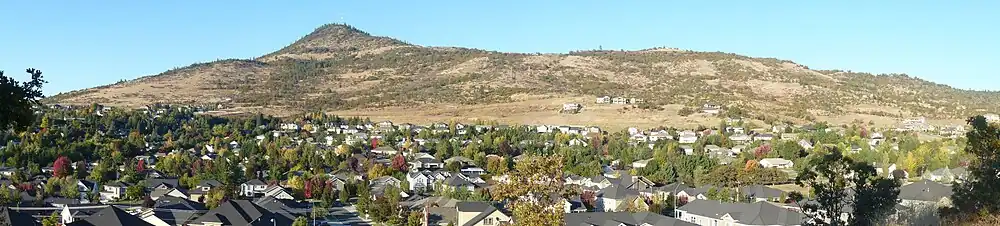 Round-topped mountain rising above hundreds of single-family residences