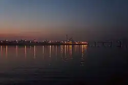 Evening view of Rybalskyi Peninsula from Trukhaniv Island with the Rybalskyi Railroad Bridge [uk] on the right.