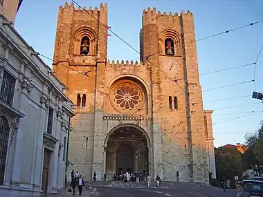 The facade of Lisbon Cathedral has two bell towers in the Norman manner and a wheel window.