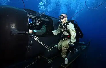 A Navy diver and special operator from SEAL Delivery Team 2 operate an SDV from the nuclear-powered guided-missile submarine USS Florida (SSGN-728)