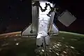 Endeavour, backdropped by a night time view of Earth and a starry sky