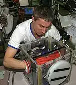 Sergei Krikalev working with a portable glovebox at the International Space Station