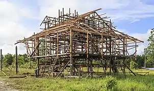 The wooden frame of a house under construction, with the floor raised off the ground