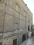 Exterior of the mosque, with the former shop alcoves visible along the base (now half-buried and below street level)