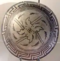 Samarra plate, with an abstract rim, a circle of eight fish, and four birds catching four fish that swim towards a central swastika; circa 4000 BC; painted ceramic; diameter: 27.7 cm; Vorderasiatisches Museum Berlin