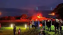 a performance at night in an outdoor grass amphitheatre