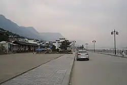 On the Yangtze waterfront near Sandouping town center (Huanglingmiao Village), looking west toward Xiling Bridge and the Three Gorges Dam (not visible because of fog)