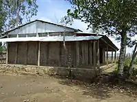 One-room schoolhouse with woven bamboo walls and corrugated tin roof