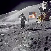 David Scott salutes the American flag during the Apollo 15 mission. The arms of the crosshair are washed-out on the white stripes of the flag (Photo ID: AS15-88-11863).