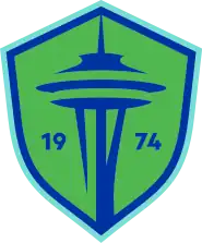 The Seattle Sounders FC crest, a green and blue shield with the shape of the Space Needle in the center and the year of the club's founding (1974).