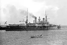 A black and white picture of a large ship with a small, lifeboat-sized ship in front of it