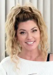 A headshot of singer Shania Twain, against a white background.