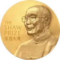 A gold circular medal with a depiction of an elderly man with glasses wearing a jacket buttoned to the neck; the English words "The Shaw Prize" and Chinese characters "邵逸夫獎" engraved on it