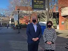 John Horgan, Premier of British Columbian, standing next to retired Sherri Bell, President of Camosun College. In the background you can see the campus including 50th anniversary banners.