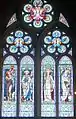 The east window, Eaton Hall Chapel, designed by Frederic Shields (the altar unusually is at the west end), this shows the stained-glass of light colours that allow plenty of light through that Waterhouse liked, also his use of geometrical window tracery. The main figures depicted are John the Baptist, Saint Peter, James the Great and John the Apostle