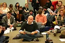 Group of young people with papers, sitting on a floor