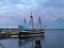 18th century replica of a wooden Dutch flute ship named Hector floating in harbour