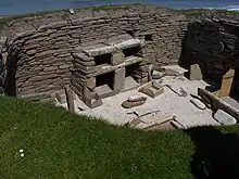 A dresser with shelves furnishes a house in Skara Brae, a settlement in what is now Scotland that was occupied from about 3180–2500 BC