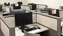 In this computer lab, every other workstation has been closed off to increase the distance between people working, and screens between workstations are also in place.