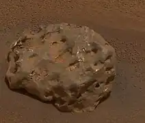 Figure 8. An example iron-nickel meteorite, Heat Shield Rock, with many hematite spherules in the background. Heat Shield Rock can also be seen in Figure 3 as a small dot about 20 m to the left of the discarded heat shield (hence the meteorite's name). It is large. Its longest dimension is 31 cm, i.e. roughly basketball-sized. Large iron-nickel meteorites were occasional featured finds by Opportunity, the rover found six of them. Image taken on Sol 346 (2005-02-01).