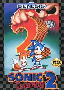 Sonic (an anthropomorphic blue hedgehog, right) and Tails (an anthropomorphic fox, left) stand confidently in front of a massive, checkered "2". A giant hand grips the top of the "2" on the left, and the face of Doctor Robotnik, a scowling, mustached mad scientist, looms in the background. Below Sonic and Tails, the words "Sonic the Hedgehog 2" sit. A black-and-gray checkered border surrounds the illustration, and Sega's seal of quality sits on Sonic's right.