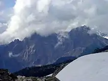 Jagged mountain with its summit hidden in clouds.