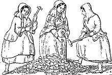 Three women wearing heavy clothing and long bonnets, carrying long hammers, standing around a pile of rocks