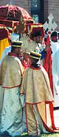 Ethiopian Orthodox clergy lead a procession in celebration of Saint Michael. During such processions, the clergy carry Ethiopian processional crosses and ornately covered tabots around the church building's exterior (Garland, Texas)