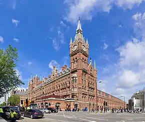 red stone building with tall clock tower in corner