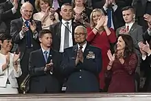 Brigadier General Charles McGee being honored by President Donald Trump at the 2020 State of the Union Address, with his great-grandson Iain Lanphier to the left and Second Lady Karen Pence to the right