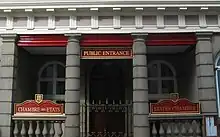 Public entrance to States Chamber in St. Helier, Jersey, showing bilingual signage in French and English