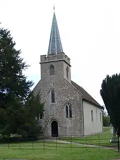 A small stone church with a spire in front