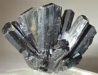 Ray of sharp, striated, iridescent metallic stibnite blades