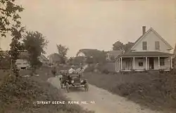 A historical automobile alongside a wooden house