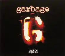 A stylized "G" resembling a branding iron. Above is "Garbage" in neon-like letters, and below "Stupid Girl".