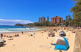 Beach with coastline at left and apartments in the background