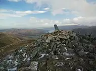 The summit cairn on Sheffield Pike, with stone boundary marker, and Ullswater beyond