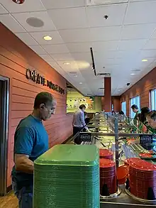 A long buffet line with a man checking out at the end