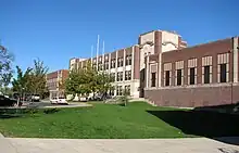 A long, three-story brick school building on top of a hill.