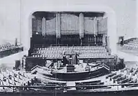 A view looking down from the balcony to the seating, rostrum and pipe organ in the church.