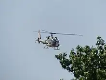 An Aérospatiale Gazelle flying above the crowd