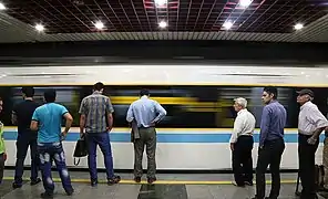 Passengers wait to board a train in 2018