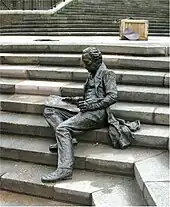 Thomas Attwood, empty plinth, and scattered bronze pages on steps