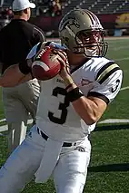 Football player in uniform appears to be getting ready to throw a football