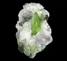 Bright green, twinned crystal of titanite with adularia and minor clinochlore on matrix