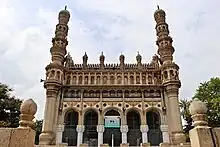 Medieval-era granite mosque surrounded by palm trees