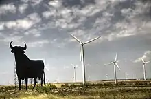 Osborne bull near a wind farm in La Muela, Zaragoza